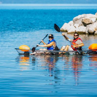 people paddling in a clear kayak on lake tahoe